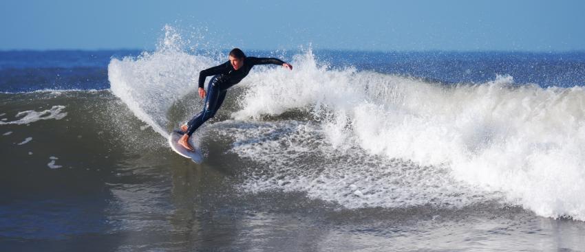 Surfer surfing in the sea in Croyde North Devon wearing a wetsuit.