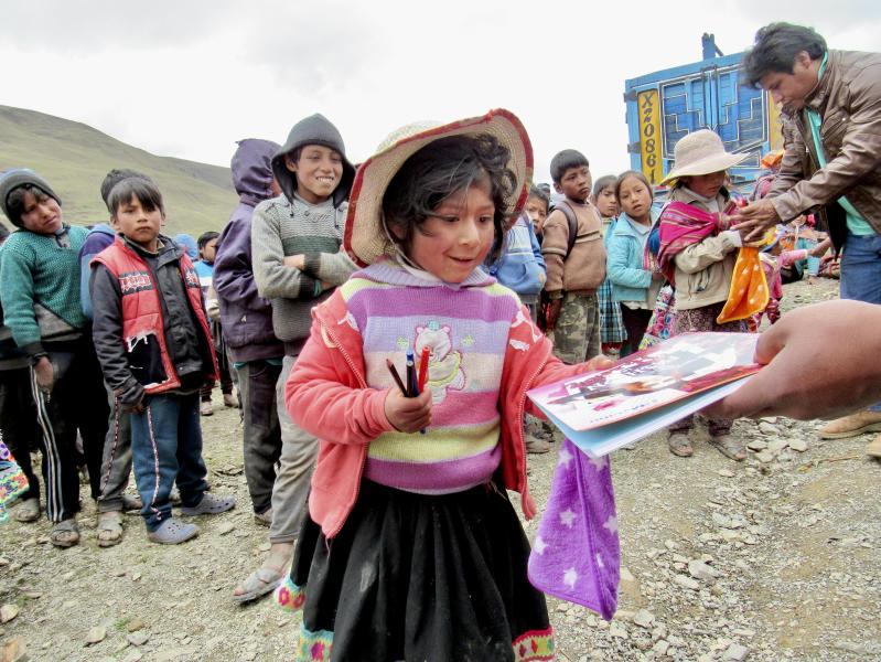Girl in Airepampa, Calca receiving coloring book