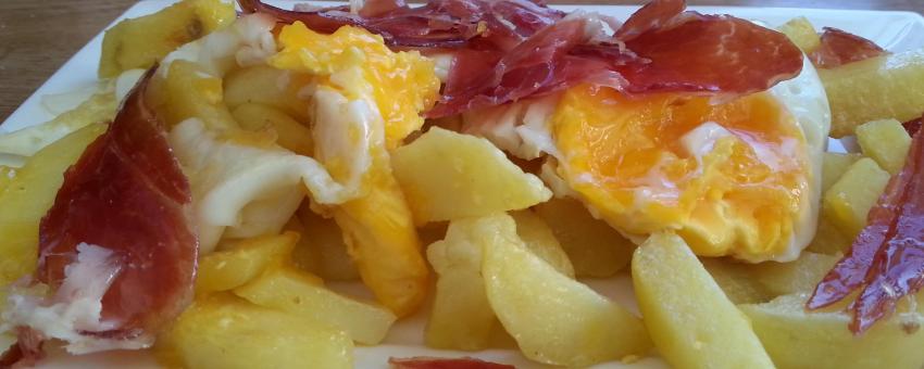 Typical Spanish dish of broken eggs with Iberian ham and potatoes.