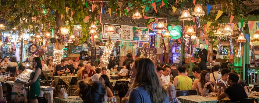 People in an open air restaurant at night time